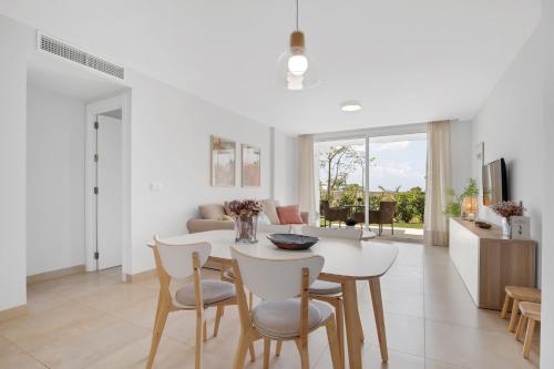 eine Küche und ein Wohnzimmer mit einem Tisch und Stühlen in der Unterkunft Luxury Apartment Leticia in La Cala de Mijas