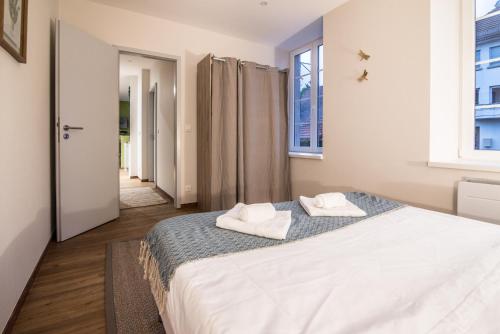 a bedroom with a bed with two towels on it at Centre Ville - Le Botanique - Parking in Drulingen