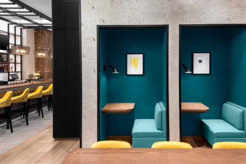 a restaurant with blue walls and yellow chairs at voco Times Square South New York by IHG in New York
