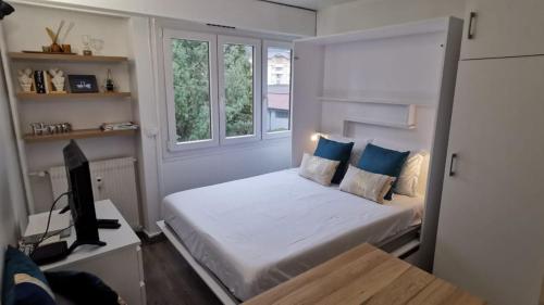 um quarto com uma cama e uma secretária com uma televisão em Portes de la vieille ville em Annecy