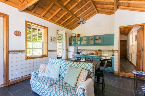 a living room with a couch and a kitchen at Tapadinho Nature and Pool - Countryside Villa in Castelo de Paiva