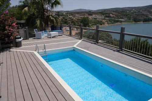 uma piscina num deque com vista para a água em פינת ביאן נוף לאגם em Majdal Shams