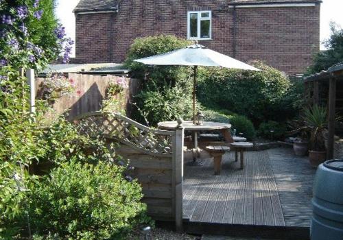 a wooden deck with a table and an umbrella at Leverton House in Cambridge