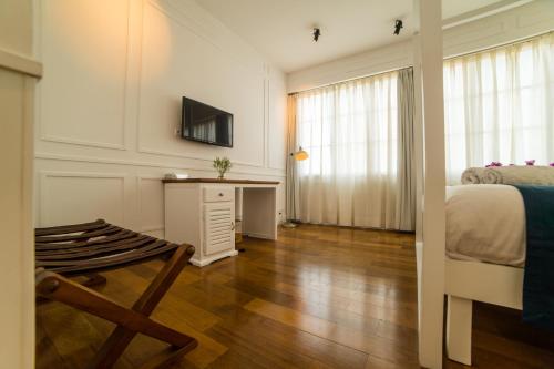 a bedroom with a bed and a desk and a tv at Grand Hotel Urban in Antananarivo