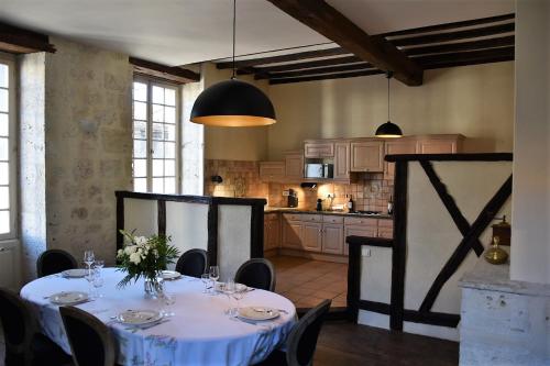 uma sala de jantar com uma mesa e uma cozinha em Maison de caractère dans la bastide foyenne em Sainte-Foy-la-Grande