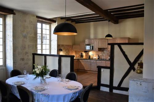 une salle à manger avec une table et une cuisine dans l'établissement Maison de caractère dans la bastide foyenne, à Sainte-Foy-la-Grande