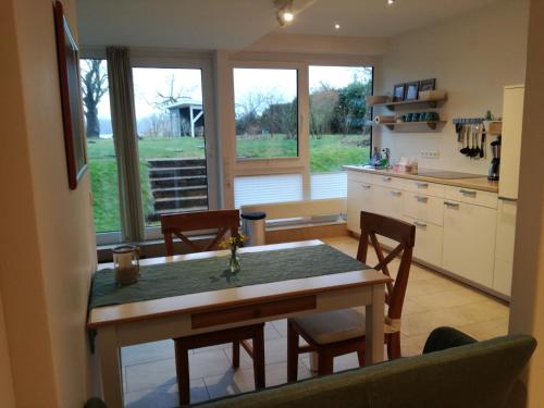 a kitchen with a table and chairs and a kitchen with windows at Ferienwohnung am Schöhsee in Plön