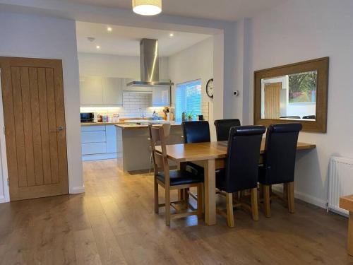 a kitchen and dining room with a wooden table and chairs at Luxury 2 bed Apartment-Golden Triangle w/ Parking in Norwich
