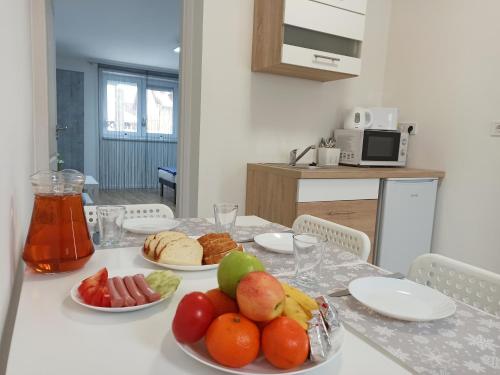 a table with plates of fruit on top of it at Grafit Apartmanok in Hajdúnánás