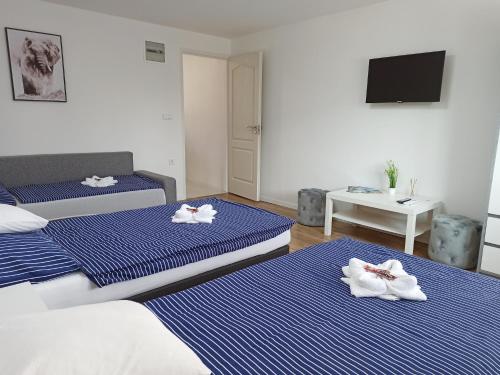 a hotel room with two beds with towels on them at Grafit Apartmanok in Hajdúnánás