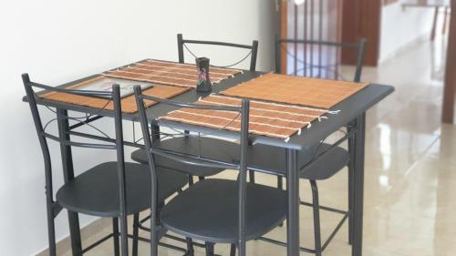 un tavolo con quattro sedie e un tavolo nero con di CHEZ JOHNNY a Grand Baie