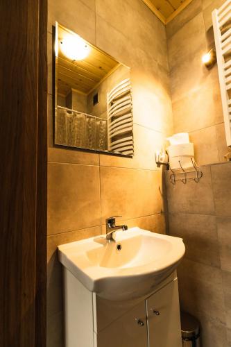 a bathroom with a white sink and a mirror at L&B Szczyrk Centrum in Szczyrk