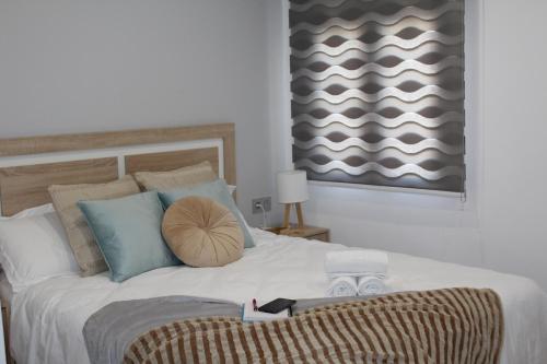 a bedroom with a large white bed with blue pillows at Apartamento Catedral in Almería