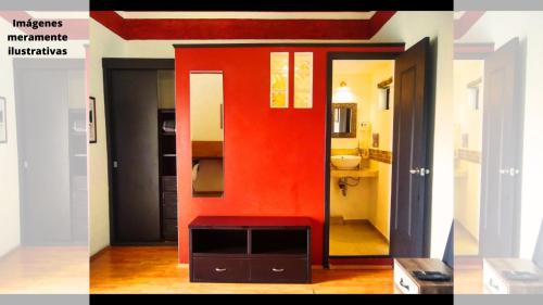a room with a red wall and a bathroom at Suites Aldama in Toluca