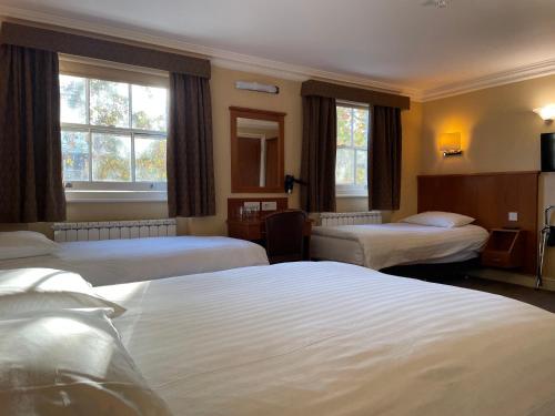 מיטה או מיטות בחדר ב-Orchard Hotel