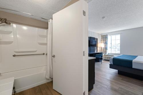 a small room with a bed and a room with a door at Studio 6 Tucson, AZ - North in Tucson