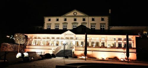 a large white building with stairs in front of it at night at Hotel Meereswelle - Anno 1875 in Ahlbeck