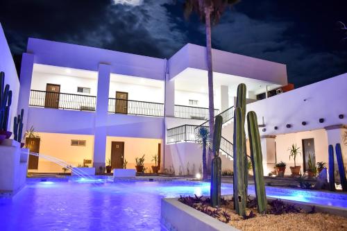 a white house with a swimming pool at night at Hotel Plaza Cuatro Ciénegas in Cuatrociénegas de Carranza