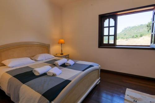a bedroom with a large bed with pillows and a window at Casa de Miraventos in Palmela