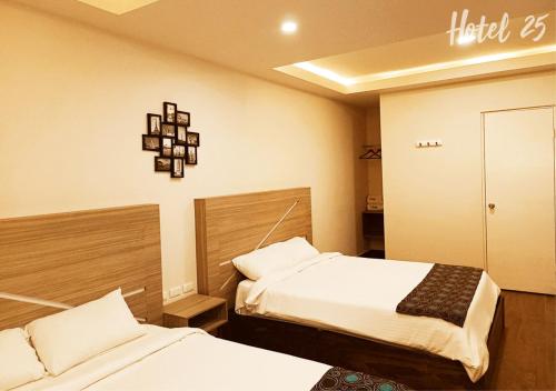 a hotel room with two beds and a sign on the wall at Hotel25 in Monterrey