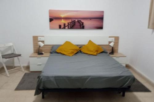 a bedroom with a bed with two yellow pillows at Spa, Sierra y sol in Cortes de la Frontera
