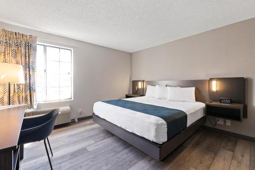 a hotel room with a bed and a desk and a window at Studio 6 Tucson, AZ - North in Tucson