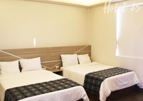 a hotel room with two beds and a window at Hotel25 in Monterrey