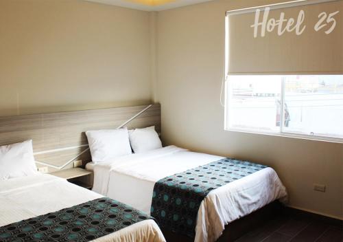 a hotel room with two beds and a window at Hotel25 in Monterrey