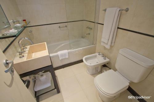 a bathroom with a toilet and a sink and a tub at Ayres Apartments Recoleta - Uriburu 1756 in Buenos Aires