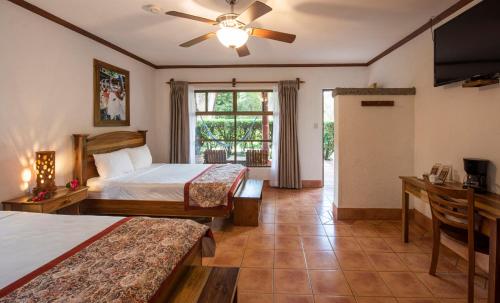 a hotel room with two beds and a ceiling fan at Hacienda Guachipelin Volcano Ranch Hotel & Hot Springs in Liberia
