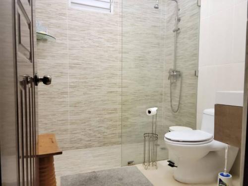 a bathroom with a toilet and a glass shower at Dulce hogar del sur, con estacionamiento gratis in Baní