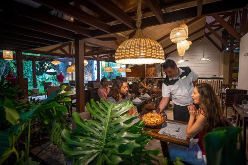 a man preparing a pizza in a restaurant at Hacienda Guachipelin Volcano Ranch Hotel & Hot Springs in Liberia