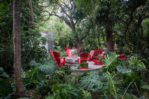 a group of red chairs in a garden with trees at Hacienda Guachipelin Volcano Ranch Hotel & Hot Springs in Liberia