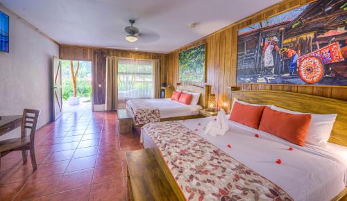 a bedroom with two beds and a painting on the wall at Hacienda Guachipelin Volcano Ranch Hotel & Hot Springs in Liberia