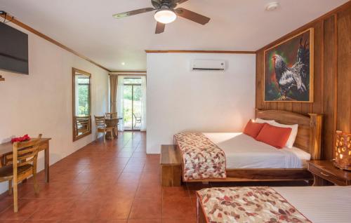 a bedroom with a bed and a dining room with a table at Hacienda Guachipelin Volcano Ranch Hotel & Hot Springs in Liberia