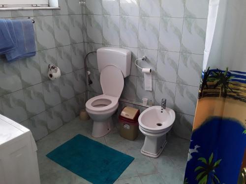 a small bathroom with a toilet and a sink at Apartament KiÇi Korce in Korçë