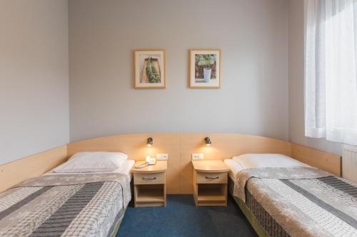 ein Zimmer mit zwei Betten und einem Schreibtisch in der Unterkunft Hotel Łabędy in Gliwice