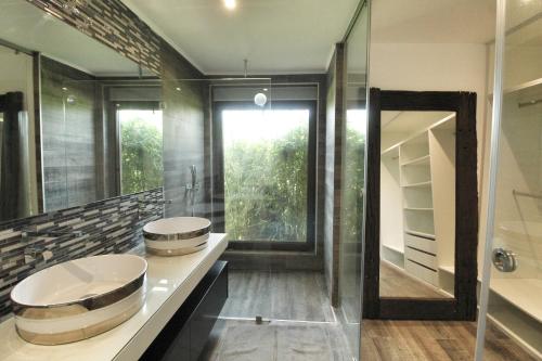 a bathroom with two sinks and a large mirror at Beautiful Algarve Pool Villa Bali 15min to beach in Mexilhoeira Grande