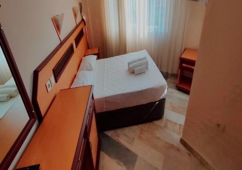 a small bedroom with a bed and a desk at Side Özgürhan Hotel in Side