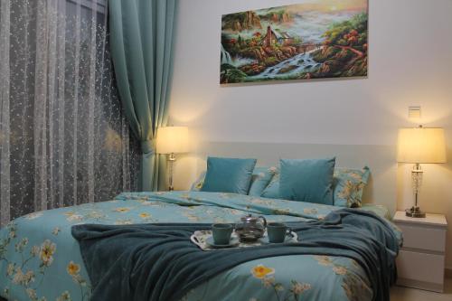 Newly furnished One Bedroom Apartment next to Metro & Beach in Marina Residence في دبي: غرفة نوم بها سرير عليه صينية طعام