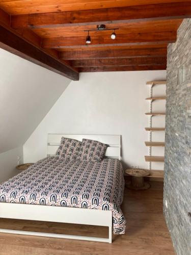 ein Schlafzimmer mit einem Bett und einer Holzdecke in der Unterkunft Ammerschwihr le cœur du vignoble in Ammerschwihr
