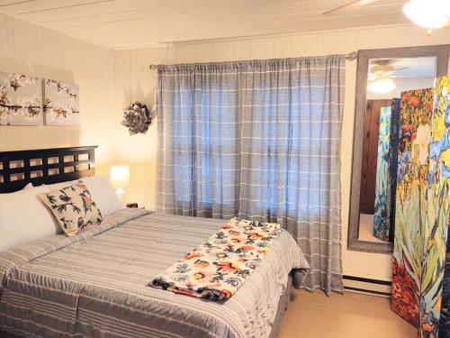 un dormitorio con una cama y una ventana en Edgewater Resort Cottage #1, en Hot Springs