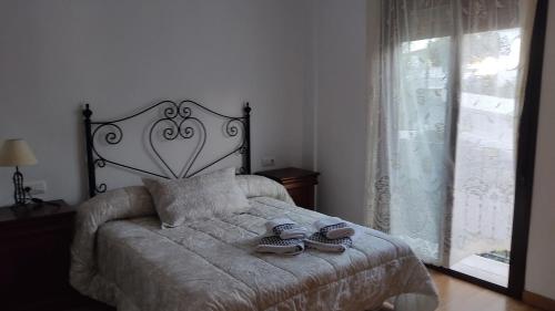 a bedroom with a bed with two shoes on it at Casa Babuche in Algar