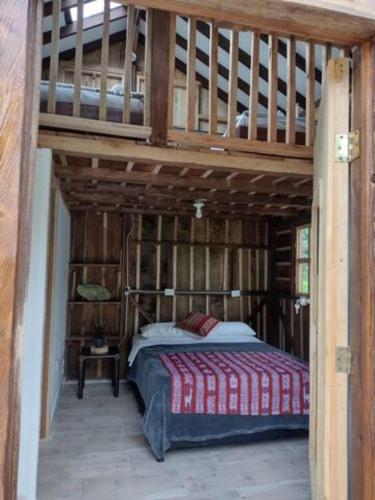 a bedroom with a bed in a wooden house at Finca Maracuba Cabañas Limón, Manzana y Níspero in Jardin