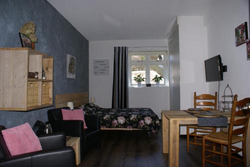 a living room with a bed and a table at Bed and Breakfast Gasteren in Gasteren
