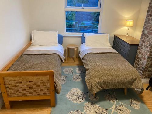2 camas en una habitación pequeña con ventana en Aeronfa, en Llanfairfechan