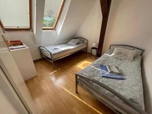 SokołowskoにあるApartament pod Stożkiemのベッド2台と窓が備わる小さな客室です。