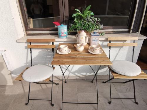 a table with two chairs and a tea set on it at Apartment Blondie Zagreb in Zagreb
