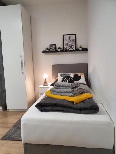 um quarto com uma cama branca com cobertores pretos e amarelos em Leon2 em Linz