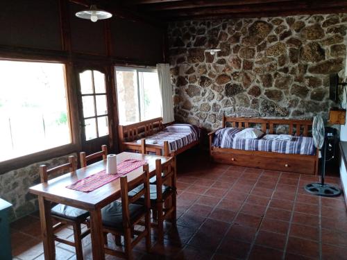 a room with two beds and a table and chairs at Campo de los Zorros in Nono